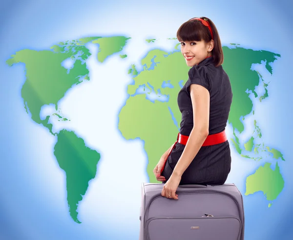 世界地図背景に手荷物を持つ若い観光女性 — ストック写真
