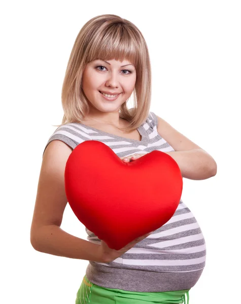 Šťastný těhotná žena drží červené srdce v rukou — Stock fotografie