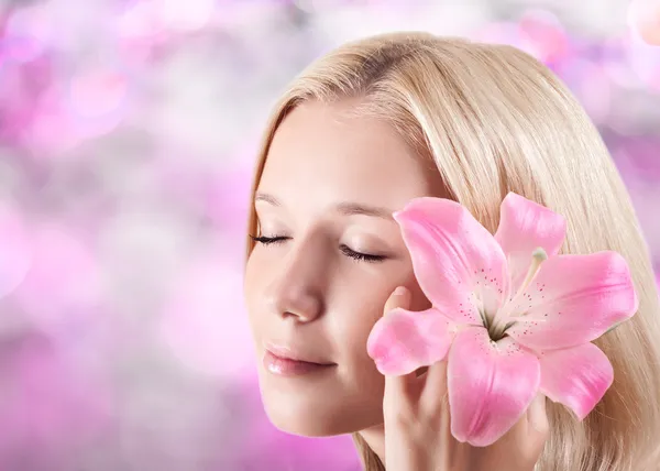 Vackra unga blonda kvinnan med lily blomma — Stockfoto