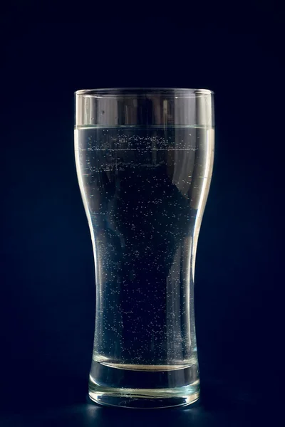 Νερό σε ποτήρι σε μπλε φόντο — Φωτογραφία Αρχείου
