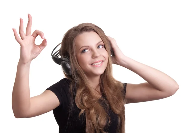 Atraente mulher sorridente com fones de ouvido no fundo branco — Fotografia de Stock