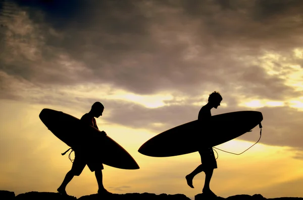 Iki sörfçü gün batımında kendi kurulları ev taşıma — Stok fotoğraf