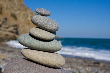 Balanced stones on sea beach clipart