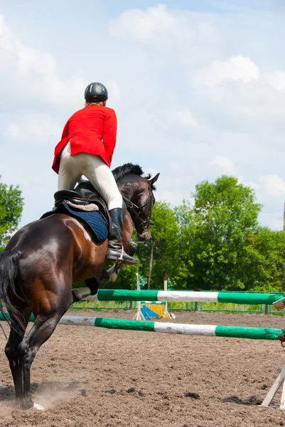 Rider jumping over the barrier — Stock Photo, Image
