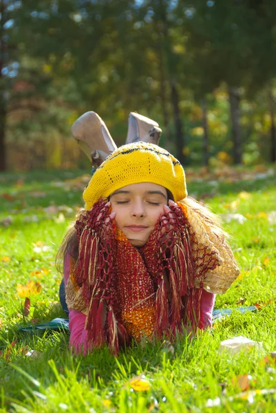 Mooi meisje liggend op een gras — Stockfoto