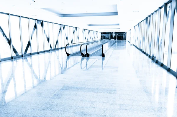 Błękitne szklanym korytarzem w centrum biurowe — Zdjęcie stockowe