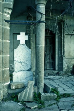 Halloween: broken creepy tombstone in front of abandoned building clipart