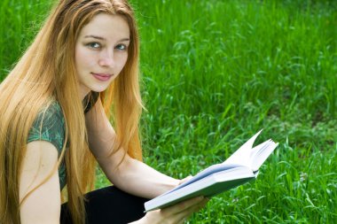 Park, çim üzerinde okumak güzel sarışın kız