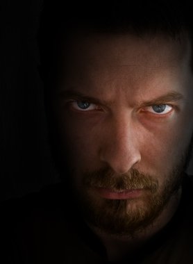 Low-key portrait - sad and angry looking man clipart