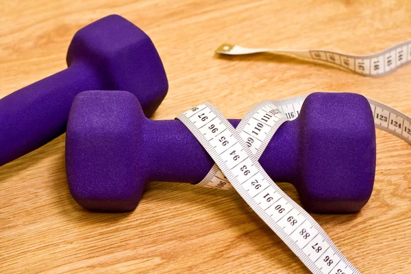 stock image Fitness and dieting concept: two dumbbells and measurement tape