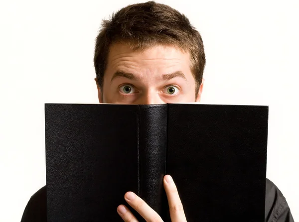 Occhi di uomo sorpreso sopra il libro nero — Foto Stock