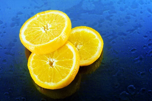 Slices of an orange on blue background — Stock Photo, Image