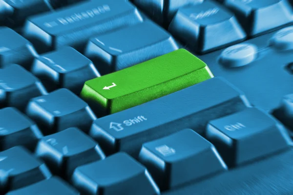 Green button on a blue keyboard — Stock Photo, Image