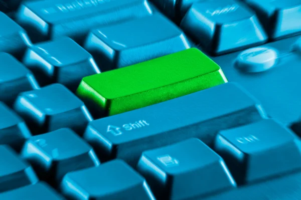 Tecla em branco verde em um teclado de computador azul — Fotografia de Stock