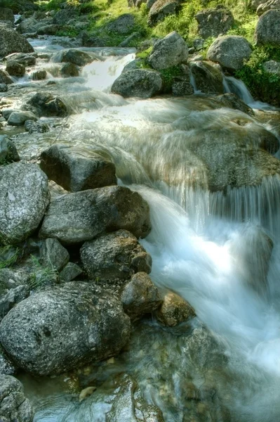 Water falling through mountain rocks — Stock Photo, Image