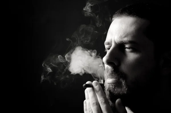 Мужчина курит в темноте — стоковое фото