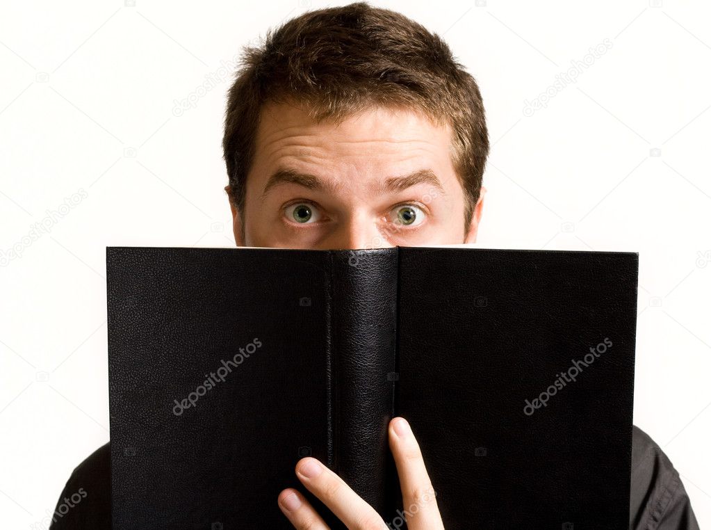 Eyes of surprised man above black book