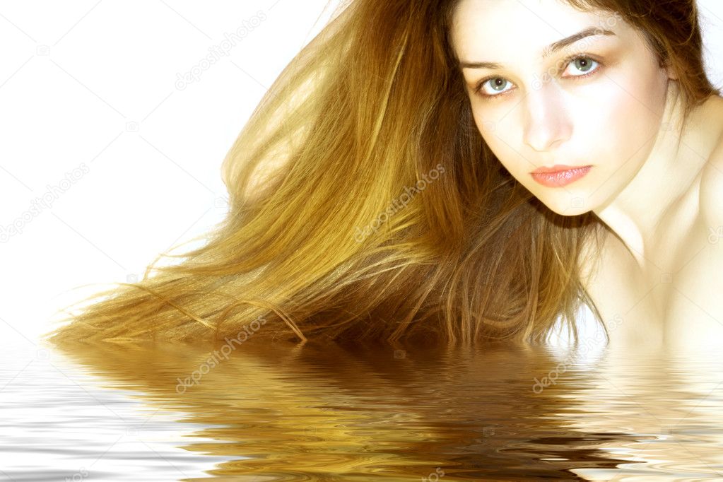 Beautiful girl with long hair, reflectin in water