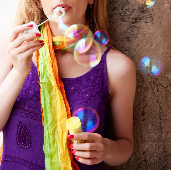 Donna che soffia bolle di sapone colorate — Foto Stock