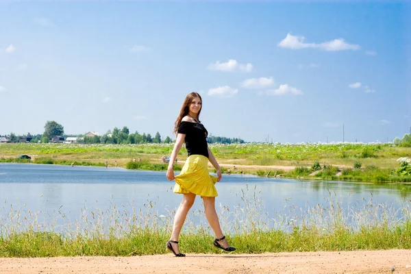 stock image Woman walking near the lake on a sunny summer day