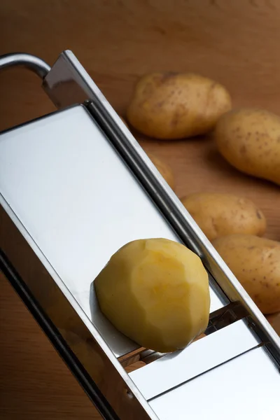 Половина картошки на мандолиновой нарезке — стоковое фото
