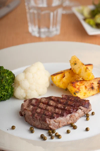 Juicy steak on a wooden table — Stock Photo, Image