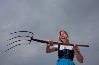 Angry bavarian girl with a pitchfork clipart