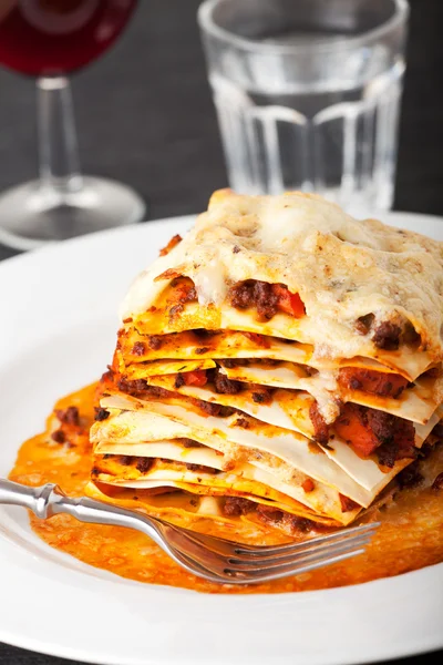 stock image Closeup of lasagna with red wine