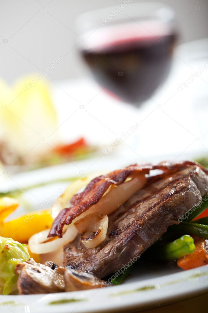 Bacon on a steak with vegetables