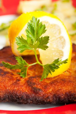 Closeup of a lemon slice on a wiener schnitzel clipart