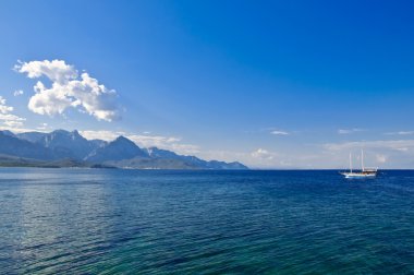 Sea, sky, mountains and small ship clipart