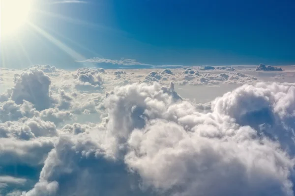 Die stürmischen Wolken leuchteten von oben mit der Sonne. Blick aus dem Flugzeug. — Stockfoto
