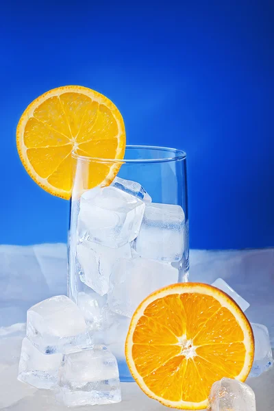 stock image Empty Glass with orange slices stand on ice plate