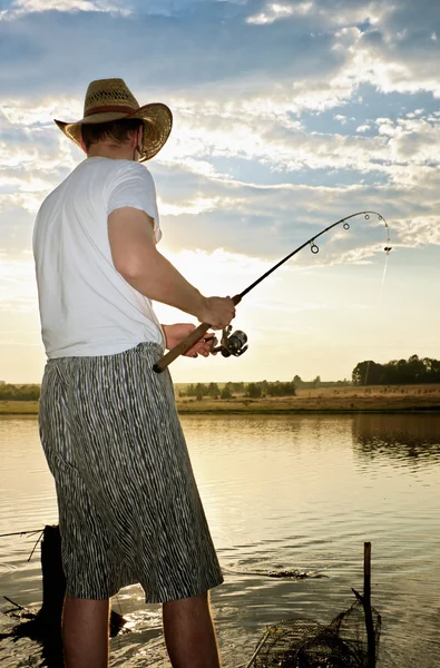 漁師は紡績魚をキャッチしているし それをドラッグ — ストック写真