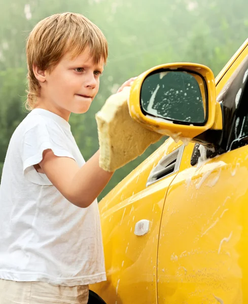 Kis fiú mosás sárga autó. — Stock Fotó