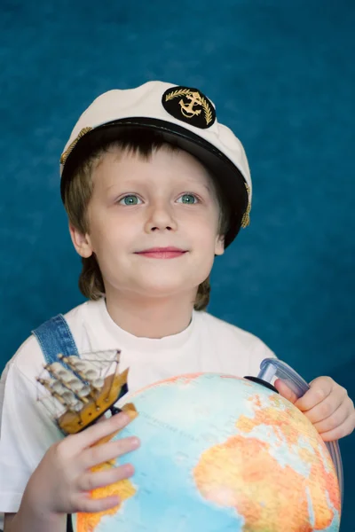 Симпатичный мечтательный ребенок с моделью глобуса — стоковое фото