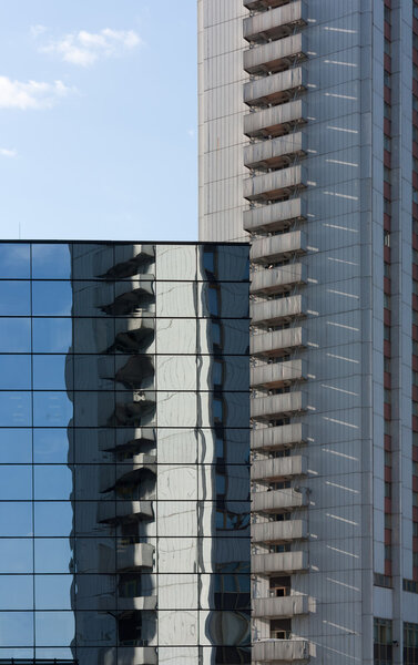 The high building is reflected in glasses of other building.