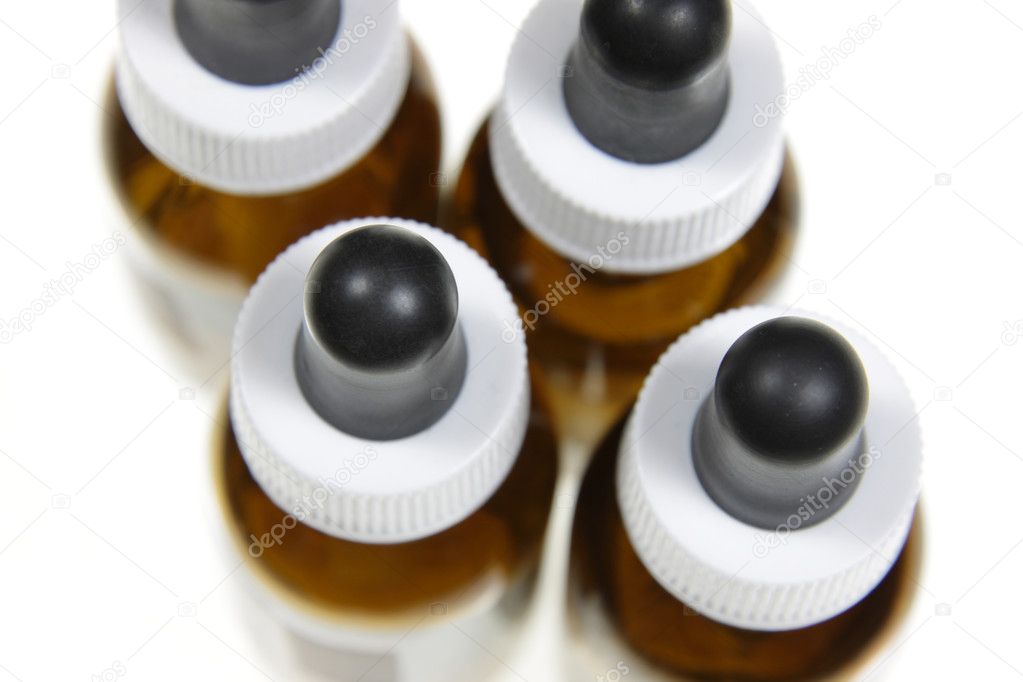 Four dropper bottles containing naturopathic medicine, isolated on a white background.