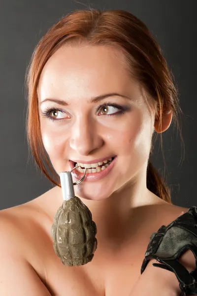 stock image Closeup portrait of a young pretty female model holding grenade pin