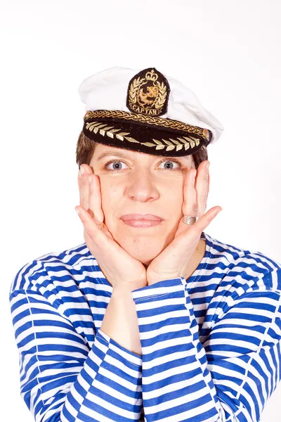 Женщина средних лет, одетая как моряк в полосатую рубашку и капитан шляпу позен — стоковое фото
