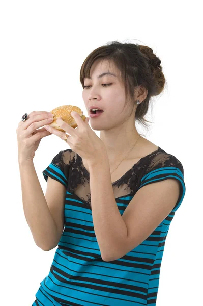 Młoda kobieta jedzenie hamburgera — Zdjęcie stockowe