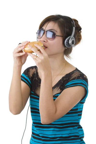 Mulher com hambúrguer, óculos de sol e fones de cabeça — Fotografia de Stock