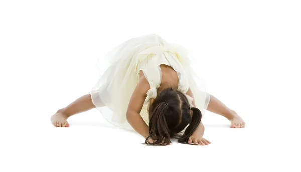 stock image Little girl trying to do the splits, isolated on white background