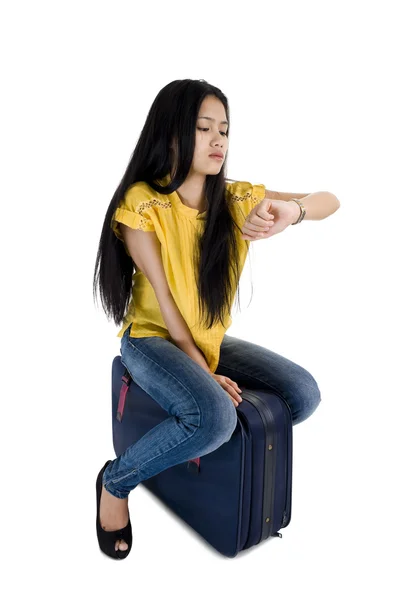 美しい若い女性は彼女のバッグに座っていると 白い背景で隔離の時間をチェック — ストック写真