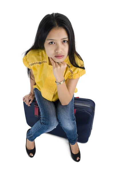 Vacker kvinna sitter på en väska — Stockfoto