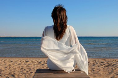 Woman sitting on beach clipart