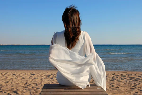女人坐在海滩上 — 图库照片