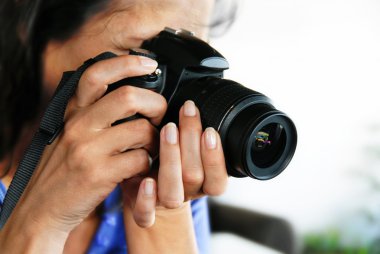 Woman photographer, black camera in woman hands closeup clipart