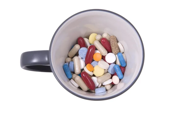 Beker van veelkleurige tabletten en capsules — Stockfoto