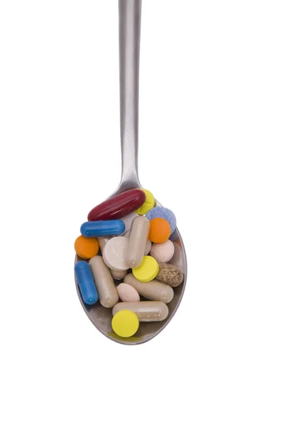 Teaspoon with pills and capsules — Stock Photo, Image